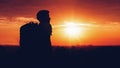 Silhouette of man hiker standing on rocky mountain peak with sunset golden sky feeling of freedom Royalty Free Stock Photo