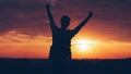 Silhouette of man hiker standing on rocky mountain peak with sunset golden sky feeling of freedom Royalty Free Stock Photo