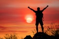 Silhouette of man hiker standing on rocky mountain peak with sunset golden sky feeling of freedom Royalty Free Stock Photo