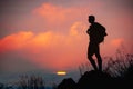 Silhouette of man hiker standing on rocky mountain peak with sunset golden sky feeling of freedom Royalty Free Stock Photo