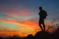 Silhouette of man hiker standing on rocky mountain peak with sunset golden sky feeling of freedom Royalty Free Stock Photo