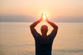 Silhouette man with his hands raised at sunset on beach arms out to sides Royalty Free Stock Photo