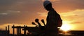 Silhouette of Man Holding Golf Clubs Against the Sunset Skyline