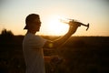 Silhouette of a man holding small compact drone and remote controller in his hands. Pilot launches quadcopter from his Royalty Free Stock Photo