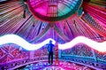 Man with snowboard inside Yurt nomadic house with red lights