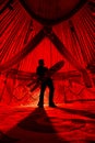 Man with snowboard inside Yurt nomadic house with red lights