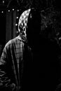 Silhouette of a man in a hood in the dark. black and white photography