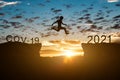 Silhouette of man jump on the cliff between 2020 covid-19 to 2021 years