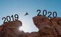 Silhouette a man jumping across cliff from 2019 to 2020