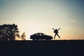 Silhouette of a man jumping for joy near a car. Royalty Free Stock Photo