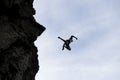 Silhouette of man jumping off cliff Royalty Free Stock Photo