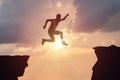 Silhouette of man jumping over a gap at sunset Royalty Free Stock Photo