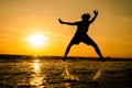 silhouette of a man in a jumping position In the sea at sunse