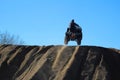 silhouette of a man jumping with a quad against a blue sky Royalty Free Stock Photo