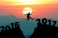 silhouette man jumps to make word Happy New Year 2017 with sunrise. (New Year 2017 is coming concept.)