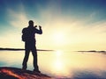 Silhouette of man keep memories with camera phone in his hand. Marvelous sunset at sea Royalty Free Stock Photo