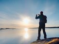 Silhouette of man keep memories with camera phone in his hand. Marvelous sunset at sea Royalty Free Stock Photo