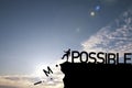 Silhouette man kicking alphabet from cliff to change impossible to possible with cloud blue sky , Positive mindset concept Royalty Free Stock Photo