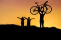 Silhouette the man lifting bicycle above his head with little girl having fun on sunset Royalty Free Stock Photo