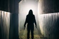 Silhouette of man maniac or killer or horror murderer with knife in hand in dark creepy and spooky corridor Royalty Free Stock Photo