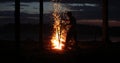 Silhouette of a man near the fire at night against the sky Royalty Free Stock Photo