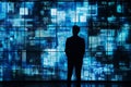 Silhouette of a man observing a large screen displaying complex blue digital patterns Royalty Free Stock Photo