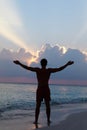 Silhouette Of Man With Outstretched Arms On Beach