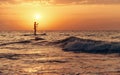 Silhouette of man on paddle board in sea at sunset. Royalty Free Stock Photo