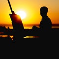 Silhouette of a man painting a picture with paints on canvas on an easel on nature, boy with paint brush and palette engaged in ar Royalty Free Stock Photo