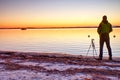 Silhouette of photographer take photo of fall offshore with beautiful sunset sky Royalty Free Stock Photo