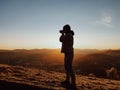 A man photographer taking pictures in front of autumn mountains landscape Royalty Free Stock Photo