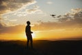 Man piloting a drone during the sunrise