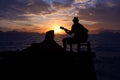 Silhouette man playing a guitar on the boat with blue sky sunrise Royalty Free Stock Photo