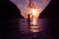 Silhouette of a man playing with sea water and the big fish jumping by the beach at sunrise Royalty Free Stock Photo