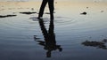 Silhouette of man practiceing qigong exercises at sunset by the sea