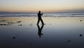 Silhouette of man practiceing qigong exercises at sunset by the sea