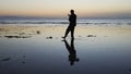 Silhouette of man practiceing qigong exercises at sunset by the sea