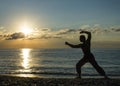 Silhouette of a man practises wing chun on the beach Royalty Free Stock Photo