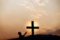 Silhouette of a man prayer in front of cross on mountain at sunset. concept of religion Royalty Free Stock Photo