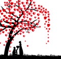 Silhouette of a man presenting a heart on his knee to a beautiful woman under a love tree in the spring season Royalty Free Stock Photo