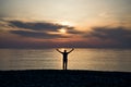 Silhouette of a man with raised arms in the sea water at sunset Royalty Free Stock Photo