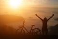 Silhouette of man raised his hand with a bike against sunset Royalty Free Stock Photo