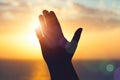 silhouette of man raising hands praying for God`s blessings at sunset or sunrise light Royalty Free Stock Photo