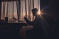 Silhouette of a man reading against a window lit in morning sun is a bit dazzling Royalty Free Stock Photo