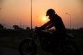 Silhouette of man riding vintage motorcycle cafe racer style with helmet Royalty Free Stock Photo