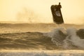 Silhouette of man riding a water scooter and jumping over a wave on sunrise Royalty Free Stock Photo