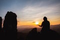 Silhouette of man rise hand up praying  on top of mountain and sunset sky abstract background. Freedom and travel adventure Royalty Free Stock Photo