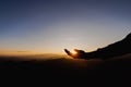 Silhouette of man rise hand up praying  on top of mountain and sunset sky abstract background. Freedom and travel adventure Royalty Free Stock Photo