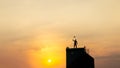 Silhouette of man on rofftop over sky and sun light background,business, success, leadership, achievement and people concept