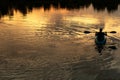 Silhouette of man rowing boat in wave lake water dark natural sunset background Royalty Free Stock Photo